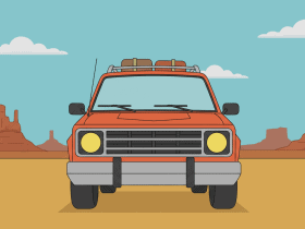 Red SUV with luggage on top, parked in a desert landscape with rock formations and blue sky in the background.