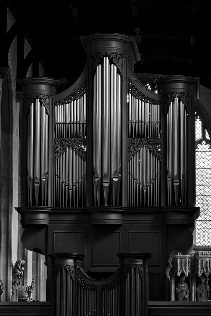 A large pipe organ in a church interior, shown in black and white.