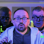 Five adults stand close together, looking surprised, under blue and purple lighting with text overlay about a film project.